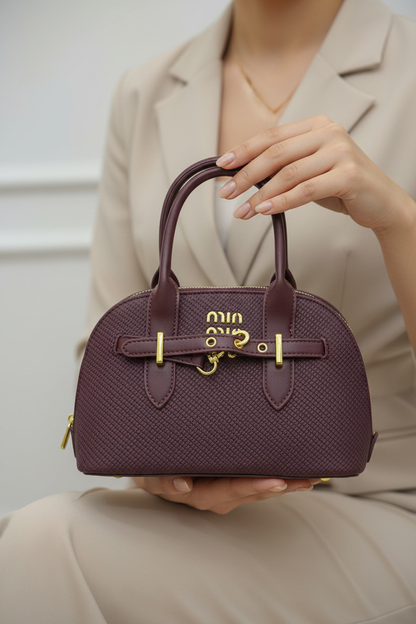 Mains tenant le sac bordeaux avec grâce